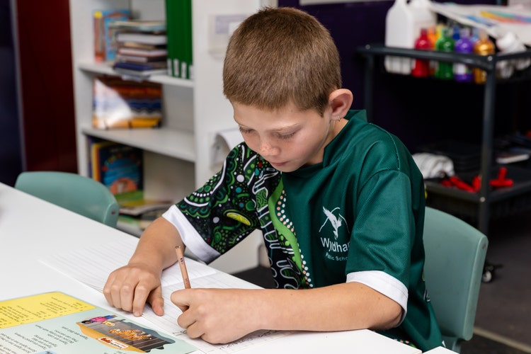 student sitting at desk writing