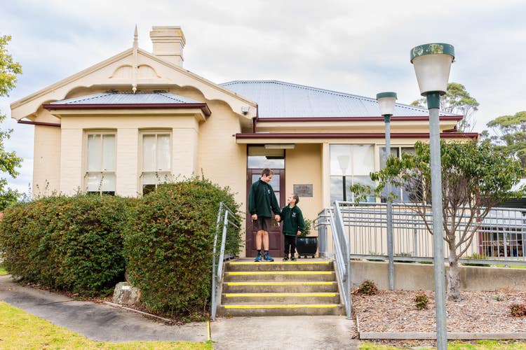 2 Students walking down stairs out of school office building