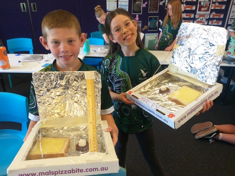 2 students with their solar pizza ovens