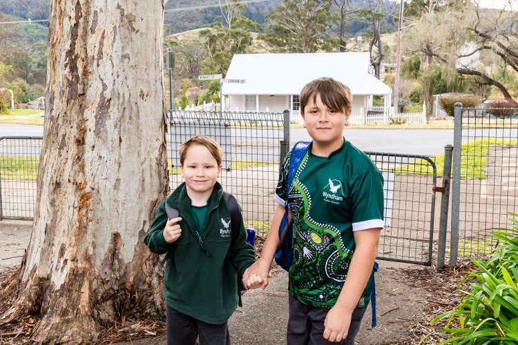 Two students walking through the school gate