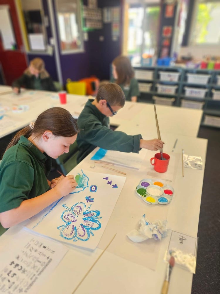 2 children painting at a desk