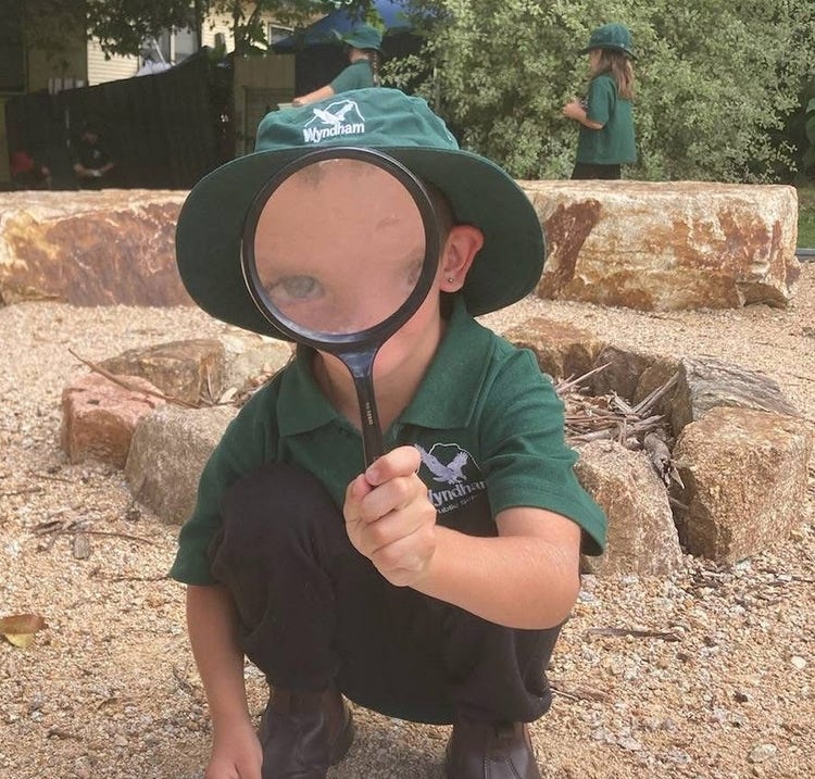 child looking through a magnifying glass